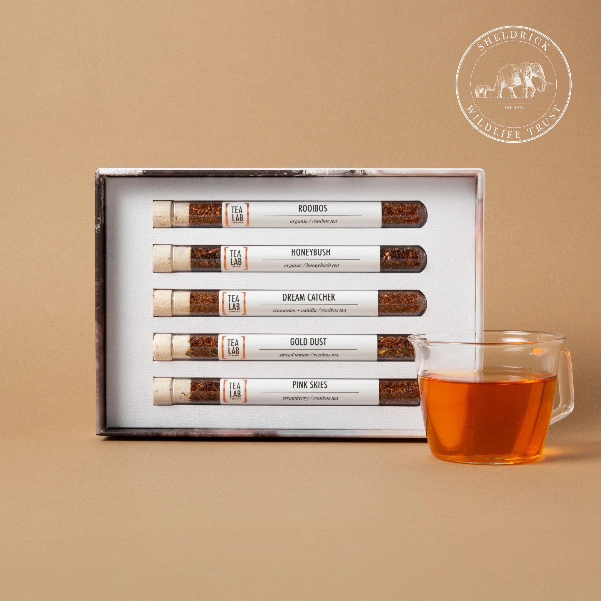 The Sheldrick Tea Collection ethical gift set by Tea Lab, featuring organic rooibos and honeybush loose leaf teas in glass test tubes. 10% of profits are donated to the Sheldrick Wildlife Trust to support elephant conservation throughout Kenya.