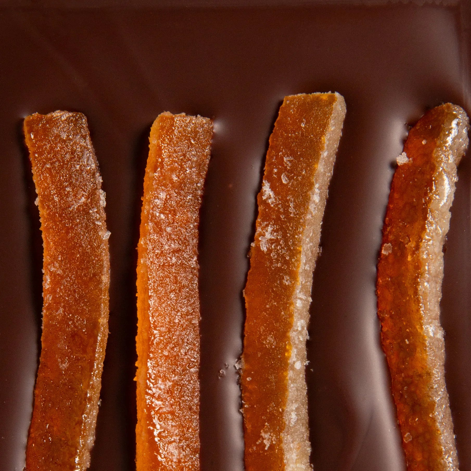 Close-up of The Chocolatier dark chocolate bar topped with candied orange strips – rich artisan chocolate available at Tea Lab
