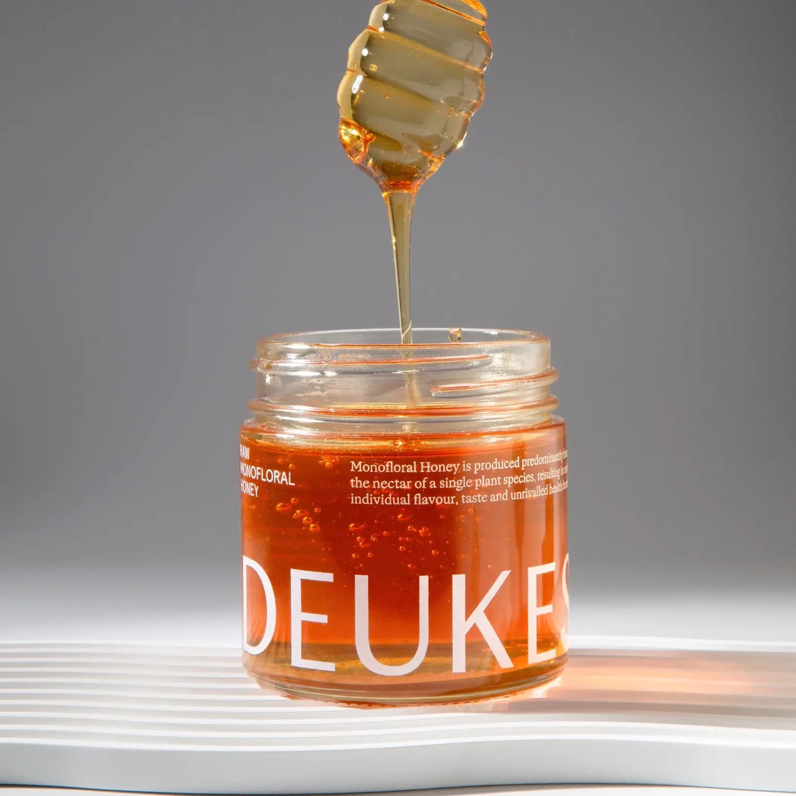 Golden monofloral sage honey by Deukes, shown in a glass jar with a honey dipper, part of the Tea Lab Pantry collection