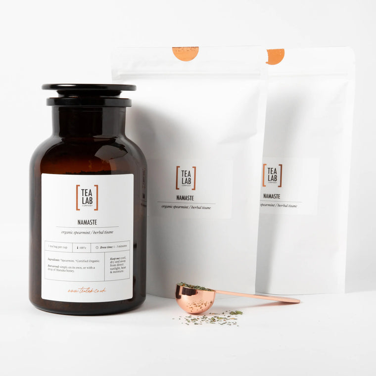 Apothecary glass storage jar gift set for loose leaf tea with 2 refillable pouches and a copper scoop.